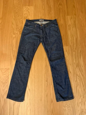 Acne Jeans Max/Deep blå jeans 33/32 - Säljer ett par klassiska blå jeans från Acne Jeans, modell Max/Deep. Jeansen har rak passform, fem fickor och är tillverkade i 100% bomull. Snygg mörkblå tvätt och diskret Acne-lapp bak i midjan. Perfekta för en clean och stilren look.