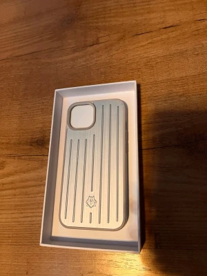 Silver metall skal ifrån Rimowa - Säljer denna helt nya mobilskal från Rimowa. Den är riktigr snygg och passar Iphone 12, 13. Box och certifierings kort ingår.
