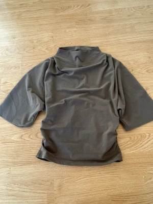 T-shirt tight i midjan  - Snygg t-shirt med trendig passform. grå/brun/ beige färg