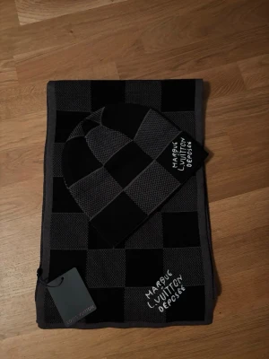 Lv mössa och halsduk  - En elegant accessoar från LV som passar perfekt inför vintern. Mjuk, värmande och stilren med exklusiv känsla. Helt oanvänd. Säljer den eftersom att den personligen inte passar min stil. Ett riktigt bra köp som motsvarar priset och lyfter vilken outfit som helst.