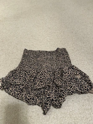 Leopardmönstrad volangkjol - Säljer en kjol med leopardmönster och volangdetaljer från Zara. De har en smockad midja som ger en skön och flexibel passform. Den har även inbyggda shorts 