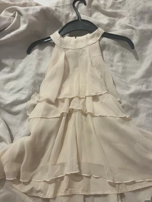 Ljus volang tröja från SHEIN - Supersöt ljus tröja från SHEIN i storlek S. Tröjan har flera lager volanger och hög hals med knapp i nacken. Tillverkad i ett tunt, flowy syntetmaterial som ger en luftig känsla. Perfekt för sommarens alla tillfällen!