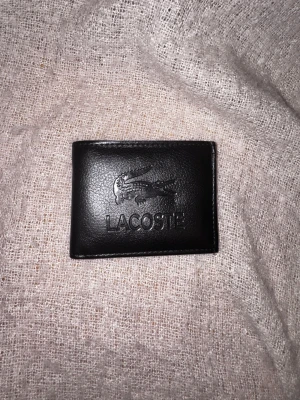  Lacoste plånbok  - Inga skador på plånboken, går att sänka pris så kom med bud. Hör av dig vid intresse.