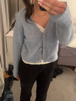 Ljusblå kofta från C.W. - Supermysig ljusblå kofta från C.W. i storlek M. Koftan har stora knappar framtill, v-ringning och är stickad i ett fluffigt material. 
