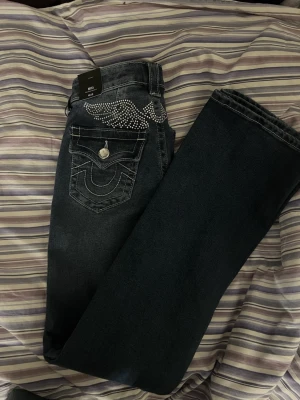 True Religion Becca Bootcut Jeans - Oanvända Mörkblå bootcut jeans från True Religion, modell Becca. En söt kristall vinge över fickorna på rumpan. Säljer pga för stor på mig💕köpt för 1599kr
