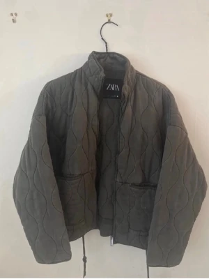 Quiltad grå pufferjacka från Zara - Säljer denna snygga trendiga och slutsålda jacka från Zara i superbra skicka!💕💕