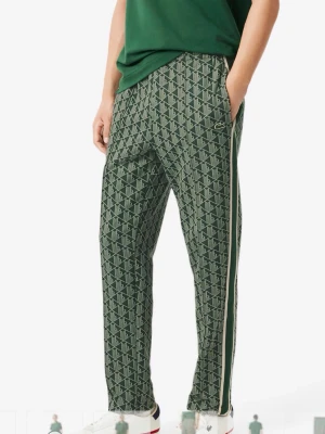 Gröna mönstrade tapered byxor Lacoste - Säljer ett par gröna tapered byxor från Lacoste med grafiskt mönster och vita sidoremsor. Byxorna har elastisk midja och diskret Lacoste-logga på benet. Sköna och stilrena, perfekta för en chill och sportig look.                                                     Säljer åt min man då de inte kommit till användning, säljer även matchande zip tröja till. 