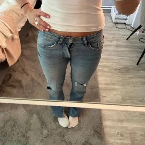 Blå raka jeans med slitningar - Fina jeans, de har tyvärr spräckt vid låtet. Är ej så hängig av mej men går säkert lätt att fixa