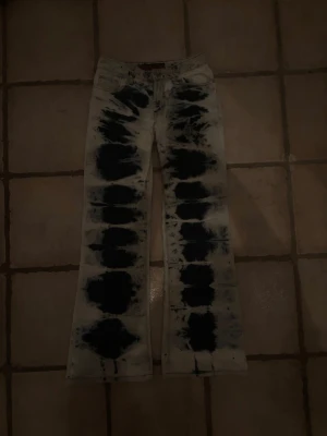 Tie dye jeans från RCC blue jeans - Unika jeans från RCC blue jeans med svart och vit tie dye-effekt. Modellen har raka ben och klassisk femficksdesign. Materialet är jeans i bomull och passformen är normal. Perfekta för dig som vill sticka ut med ett coolt mönster.