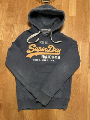 Superdry hoodie  - Riktigt snygg Superdry hoodie i storlek S men passar även M. Fint skick hör av dig gällande frågor. Blå/grå färg