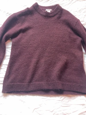 Vinröd stickad tröja  - Vinröd stickad tröja från Gina Tricot i storlek 146/152 men passar mig som har XS. Tröjan har rund halsringning, ribbade muddar och lång ärm. Perfekt för kyliga dagar och enkel att matcha med jeans eller kjol. Använd 2-3 gånger