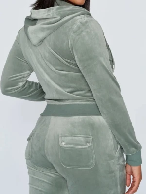 Classic Velour juciy couture set - Snygg ljusgrön velourväst från Juicy Couture med dragkedja framtill och huva. Västen har fickor på sidorna och en liten broderad logga på bröstet. Perfekt för en chill och avslappnad look. Säljer pga den inte kommer till användning längre. OBS! De är uppsprätta( ville ha de längre)!Finns en liten defekt nedre delen av ena benet. Där av prissänkningen. Defekten syns inte alls!