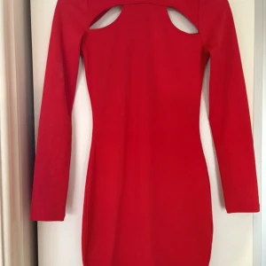 Röd ribbad klänning från Divided XS - Röd ribbad kortklänning från Divided i storlek XS. Klänningen har lång ärm och en snygg cut out-detalj upptill på ryggen. Figurnära passform och stretchigt material som känns bekvämt. Perfekt för dig som vill sticka ut med en färgstark look.