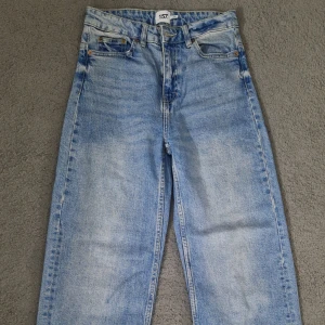 Ljusblå jeans från 157, rak modell XS - Ljusblå jeans från 157 i rak passform med hög midja. Jeansen har klassisk femficksdesign, råa fransiga benslut och tydliga slitningar för en avslappnad vibe. Tillverkade i bomullsdenim och perfekta för dig som gillar en enkel, clean look.