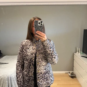 Leopardmönstrad pufferjacka Gina Tricot - Säljer en pufferjacka från Gina Tricot i storlek 38 med leopardmönster i beige och mörkbruna toner. Jackan har guldfärgade knappar framtill, ståkrage och quiltad insida. Vanligtvis brukar jag ha 34, men skulle nog säga att jackan passar 34-38 beroende på önskad passform.
