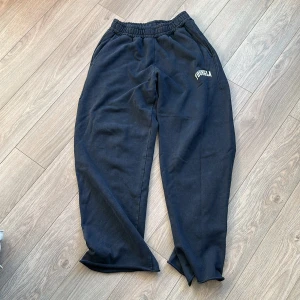 Svarta mjukisbyxor från YoungLA i storlek L - Svarta mjukisbyxor från YoungLA med elastisk midja och dragsko. Byxorna har sidofickor, en bakficka och logga på vänster lår. Tillverkade i mjuk bomullsmix för maximal komfort och avslappnad passform.