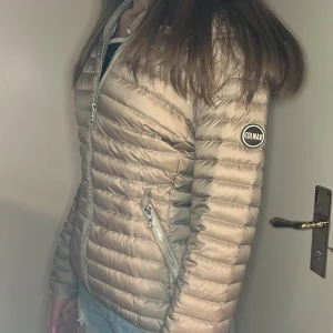 Beige pufferjacka från Colmar - Säljer en beige pufferjacka från Colmar med dragkedja framtill och två sidofickor med dragkedja. Den har en liten sminkfläck på insidan men går lätt att tvätta bort. Den är i storlek 46 men sitter som en medium/small (mina egna bilder) 