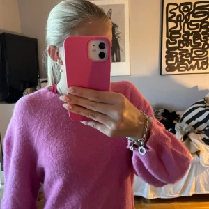 Fluffig rosa stickad tröja - Supermysig rosa stickad tröja med fluffig känsla och rund hals. Perfekt för dig som vill ha en färgklick i garderoben och gillar en lite loose fit. Långärmad modell som passar till jeans eller kjol.