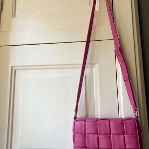 Rosa axelremsväska från Noella - Helt ny rosa axelremsväska från Noella med justerbar rem. Nypris 899 kr