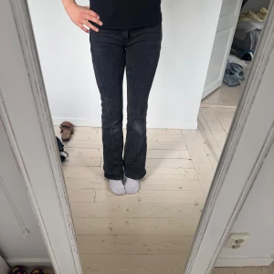 Svarta bootcut jeans - Säljer ett par svarta jeans med bootcut-modell och klassisk femficksdesign. Jeansen har en snygg mörk tvätt och raka ben som blir vidare nedtill. Midwaist.