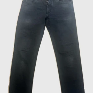 Replay mörkgrå jeans  - Säljer ett par mörkgrå jeans från Replay. Jeansen har normal passform och är tillverkade i mjukt denimtyg. Snygga detaljer med Replay-logga på fickan och bak på linningen. Svinfeta jeans som är i toppskick. W 30 L 34