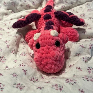Virkad rosa och lila drake  - Eftersom dessa inte såldes på vinted kommer det några fler sötnosar här! Denna draken är rosa med lila detaljer🩷💜 OBS:  !Dessa innehåller säkerhetsögon som inte rekommenderas för barn under 3 år!