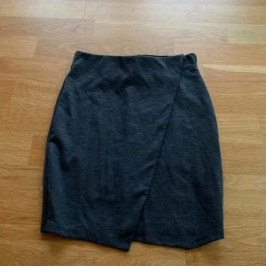 Mörkgrå omlottkjol i bomull - Mörkgrå kortkjol med omlott-design. 