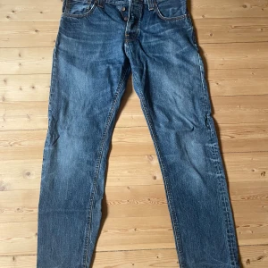 Nudie jeans Steady Eddie storlek: W 32 L 32 - Nudie jeans säljes. Säljer pga för små för mig. Finns två lagningar på jeansen, se bilder. Nypris ca 1600kr