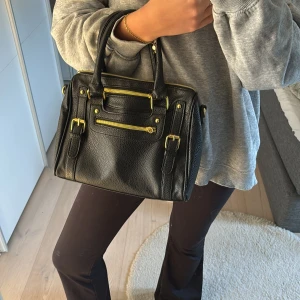 Svart handväska - Svart handväska med gulddetaljer. Knappt använd❤️