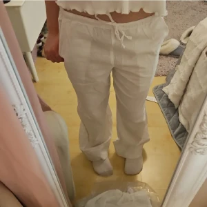 Vita linnebyxor Gina Tricot - Snygga vita linnebyxor från Gina Tricot med låg/mellanhög midja och raka ben. Perfekta för sommardagar. Väldigt genomskinliga, sitter snyggt, endast använda få gånger och i bra skick. Tyvärr så är storlekslappen avklippen men original storlek är xs, men de är uppsydda längst ner så att de passar storlek 152! Perfekta för sommaren. Nypris runt 300 kr!