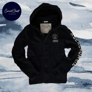 Svart hoodie från Abercrombie & Fitch - Svart hoodie från Abercrombie & Fitch med broderad logga och årtal 1892 på bröstet samt stor vit text längs ena ärmen | Size M | Axelbredd: 44cm Längd: 65cm