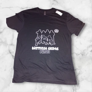 Svart t-shirt med tryck PHS23 - Ni kan alltid komma med prisförslag det är inget fast pris.Svart t-shirt med vitt tryck framtill som föreställer silhuetter av personer och texten 'Rättvisa Skipas PHS23'. Klassisk rund hals och korta ärmar. Perfekt för dig som vill sticka ut med ett statement-plagg.