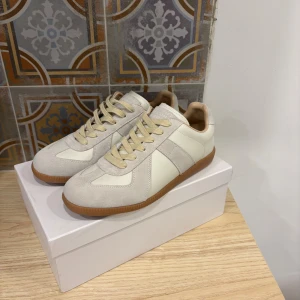 Masion Margiela  - Snygga sneakers från Maison Margiela i beige och vitt med ovandel i mocka och skinn. Använda några gånger 