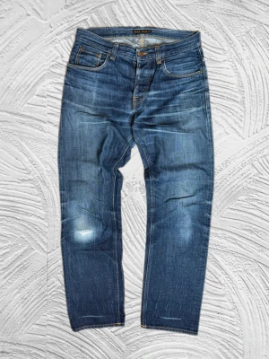 Nudie Selvedge - Extrema nudie selvedge jeans i modellen sleepy sixten, storlek W31L32 (sitter större), ytterbenslängd 104cm, midjemått 43,5cm! -enkla att matcha och sköna att bära. Ett stilrent val, noggrant utvalt med omsorg av A.M.C!  📩 Frågor? Hör gärna av dig! 📲 Följ oss här på Plick för fler uppdateringar. ♻️ Tack för att du handlar mer hållbart med A.M.C Archive!