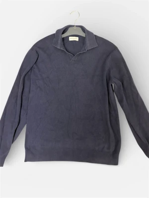 Marinblå pikétröja These Glory Days - Snygg marinblå pikétröja från These Glory Days i storlek medium. Tröjan har klassisk krage och är långärmad, perfekt för dig som gillar stilrena och enkla plagg. Materialet är mjukt och känns skönt mot huden.