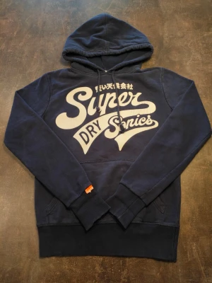 Superdry Hoddie  - Fin superdry Hoddie i bra skick har dock en röd fläck på armens baksida så inget som märks. 