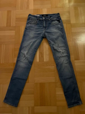 Replay Anbass Hyperflex med slitningar - Otroligt feta replay jeans i modellen Anbass med riktigt stiliga slitningar. Storlek är W30/L32 och vid frågor eller funderingar är det bara att höra av sig! 😊