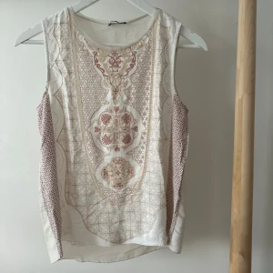 Mönstrad ärmlös topp från Zara - Supersnygg ärmlös topp från Zara med unikt mönster i beige, bruna ouch rosa toner. Framsidan har detaljerade orientaliska och geometriska tryck, medan baksidan är enfärgad. 