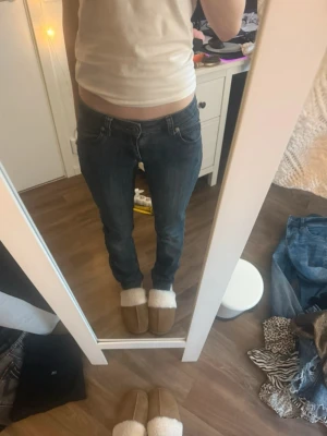 Mörkblå jeans från att. Str XS - Säljer ett par mörkblå jeans från att. i klassisk femficksmodell. Jeansen har låg midja och en slim passform som sitter snyggt längs benen. Materialet är jeans med tydliga sömmar och en stilren look. Super snygga 💕