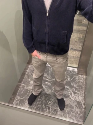 Mörkblå stickad hoodie från L.O.G.G. - Säljer en mörkblå stickad hoodie från L.O.G.G. med dragkedja framtill och huva. Tröjan har ribbade muddar vid ärmslut och nederkant samt en praktisk ficka på sidan. Perfekt för kyliga dagar och enkel att matcha med jeans eller chinos.