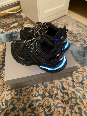 Balenciaga track led, svart - Balenciaga track med LED-ljus. Har aldrig använt. Jag fick den i present men tyckte inte om den så mycket. Allt i bilden följer med. Fråga frågor om produkten. Viktigt att veta: Paketet har liten skada. Allt annat är bra.