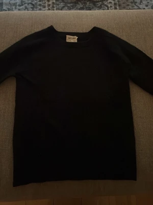 Svart kashmirtröja från Soft Goat - Mjuk och stilren svart tröja från Soft Goat i 100% kashmir. Klassisk rund hals och långärmad modell med ribbade muddar vid ärmslut. Perfekt för dig som gillar enkel och lyxig design. Den har krymt i tvätten så skulle säga att den är i storlek XS därav priset! Ordinariepris är 2 900kr!