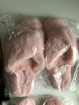 Nya Rosa fluffiga sandaler från Ivora i storlek Large- mått se bilder  - Supermjuka och fluffiga sandaler i ljusrosa från VORA. De har korslagda band över foten och en platt vit sula med räfflat mönster undertill. Materialet är syntetpäls som känns riktigt gosigt och ger en cozy vibe. Perfekt för chill hemma eller när du vill ha något extra comfy på fötterna.