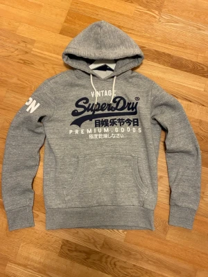 Superdry hoodie.  - Säljer denna as feta archive hoodien från de eftertraktade märket superdry. Tröjan är i storlek M. Väldigt bra skick, inga tecken på användning. Hör av er vid frågor eller funderingar. Pris kan alltid diskuteras.