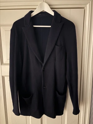 John Henric merinoull kavaj/cardigan - Helt ny populär superfin blå John Henric cardigan i storlek M säljes (100% merinoull). Jättefint plagg perfekt som cardigan. Inga hål eller fläckar och sitter grymt. I princip helt ny då den är använd 2 gånger. Tveka inte vid minsta fråga eller fundering!