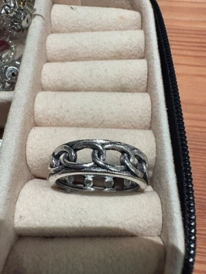Ring med kedjdetaljer -  en silverfärgad ring med kedjedetaljer.