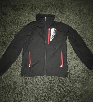 Svart vindjacka 8848 Altitude  - Svart vindjacka från 8848 Riktig schysst jacka som väldigt enkelt kan stylas i samband med annat för en snygg outfit. Höga kragen på jackan gör den riktigt unik. Jackan är i princip oanvänd och har inga defekter!