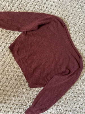 Vinröd stickad tröja från Lindex - Mysig vinröd stickad tröja från Lindex i storlek S. Tröjan har långärmade ribbade muddar och rund hals. Perfekt för kyliga dagar och enkel att matcha med jeans eller kjol. Materialet är mjukt och ger en skön känsla.