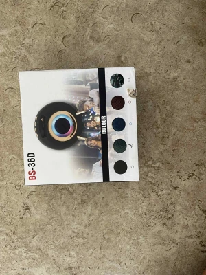 BS-36D Portable Wireless Speaker - BS-36D är en portabel trådlös högtalare med Bluetooth, USB, TF-kort och FM-radio. Snygg design med kamouflagemönster och färgval. Perfekt för musik på språng. Kartongen har mindre slitage men produkten är i nyskick.