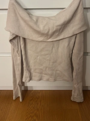 Beige ribbad offshoulder topp Gina Tricot - Säljer en beige ribbad offshoulder topp från Gina Tricot i storlek XS men passar oxå S. Toppen har långa ärmar och en bred krage som vilar snyggt över axlarna. Materialet är mjukt och stretchigt, perfekt att styla med jeans eller kjol. pris kan diskuteras!!